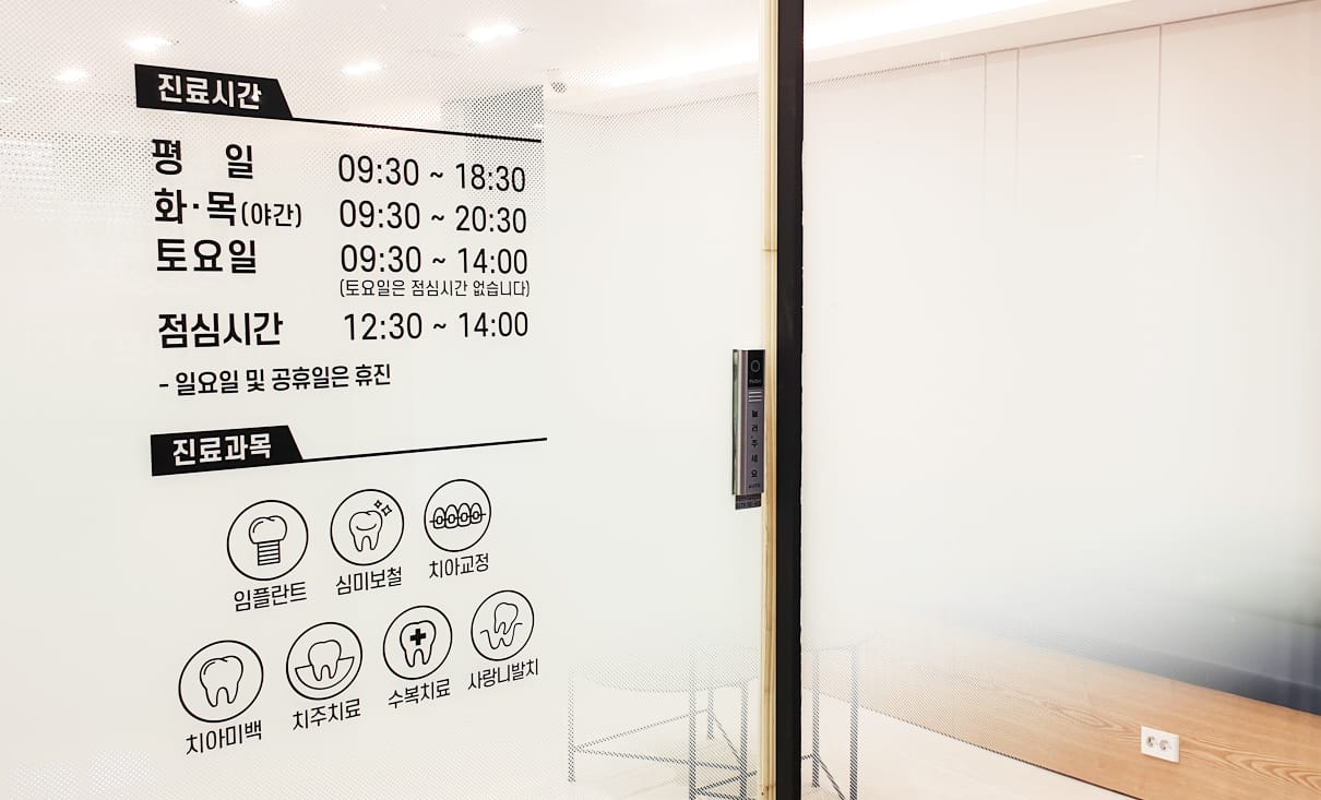 입구 유리문에 붙은 진료시간과 진료과목 안내